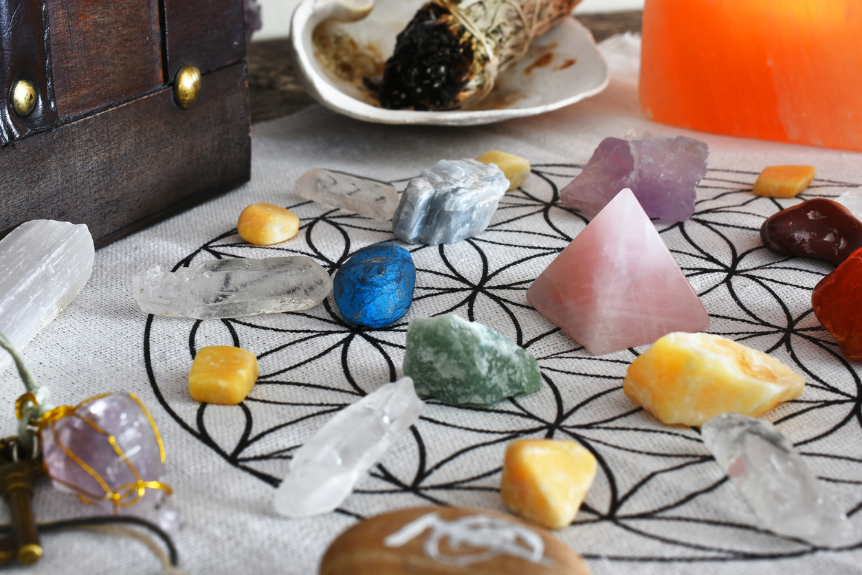 A close up image of a chakra healing grid using a pink rose quartz pyramid and sacred geometry.